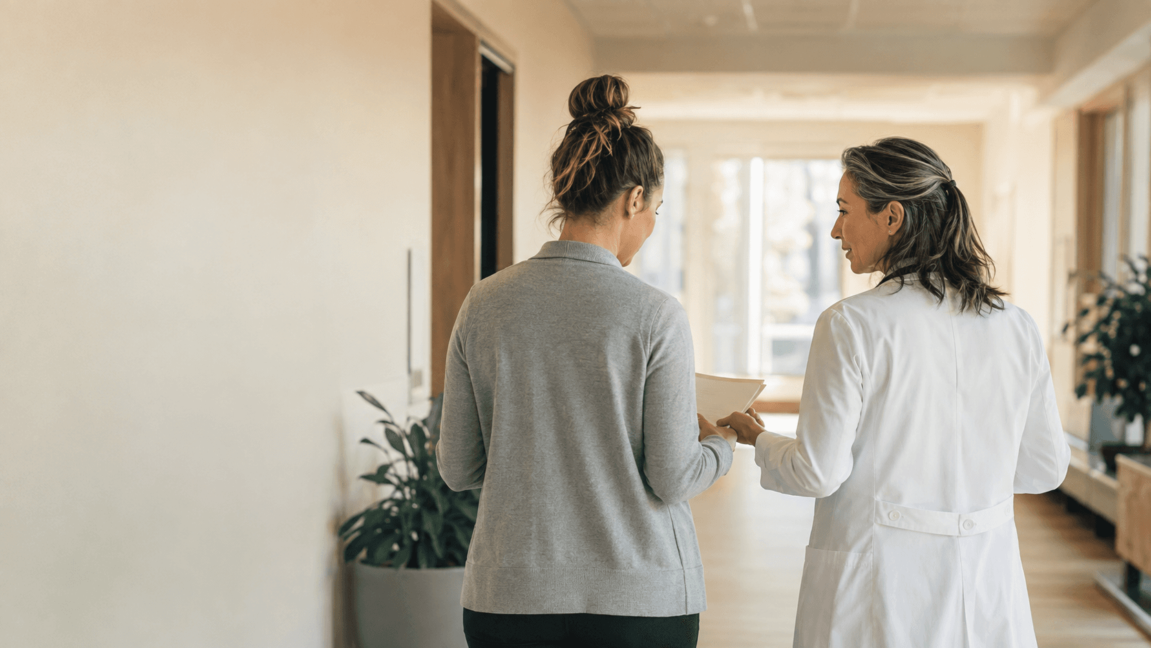 A physician and care coordinator walking together in a clinic